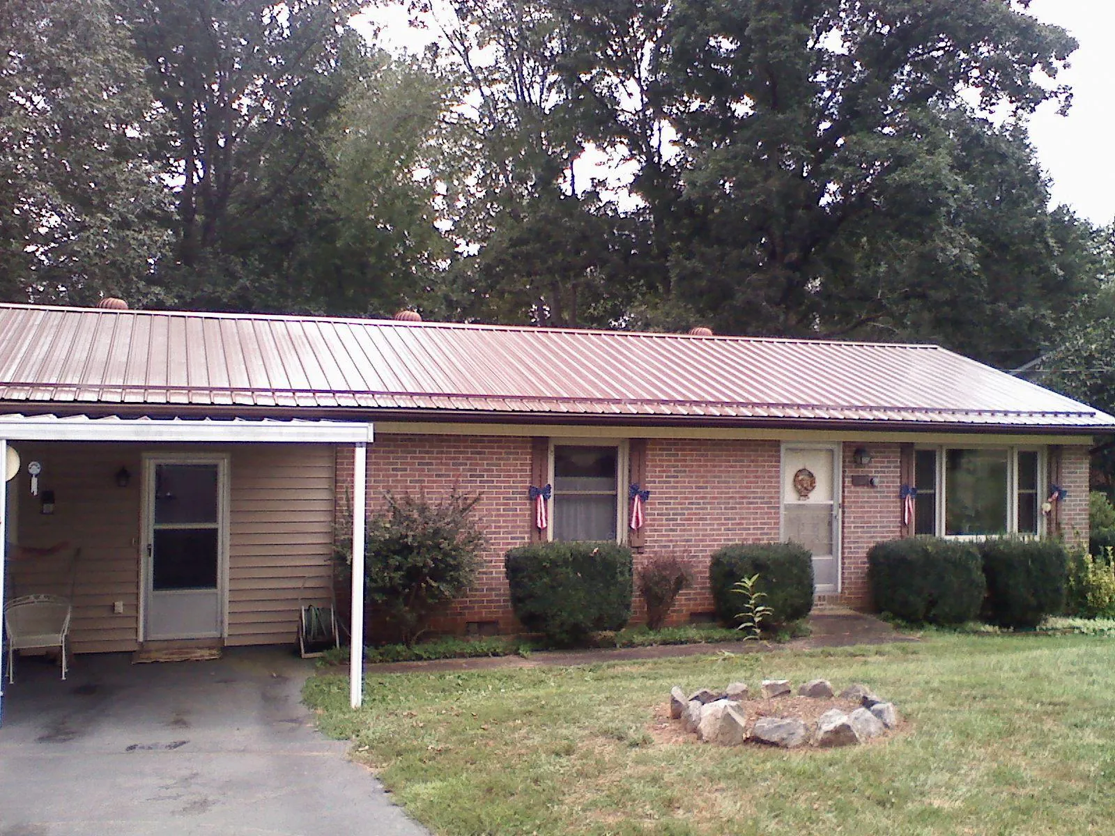 Bronze metal roof and carport on a brick ranch home — Roof Repair work by our crew in Lakeview